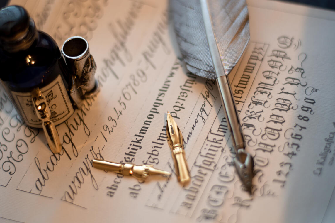 macro-shot-quill-set-ink-bottle-piece-paper-with-calligraphy-it.jpg