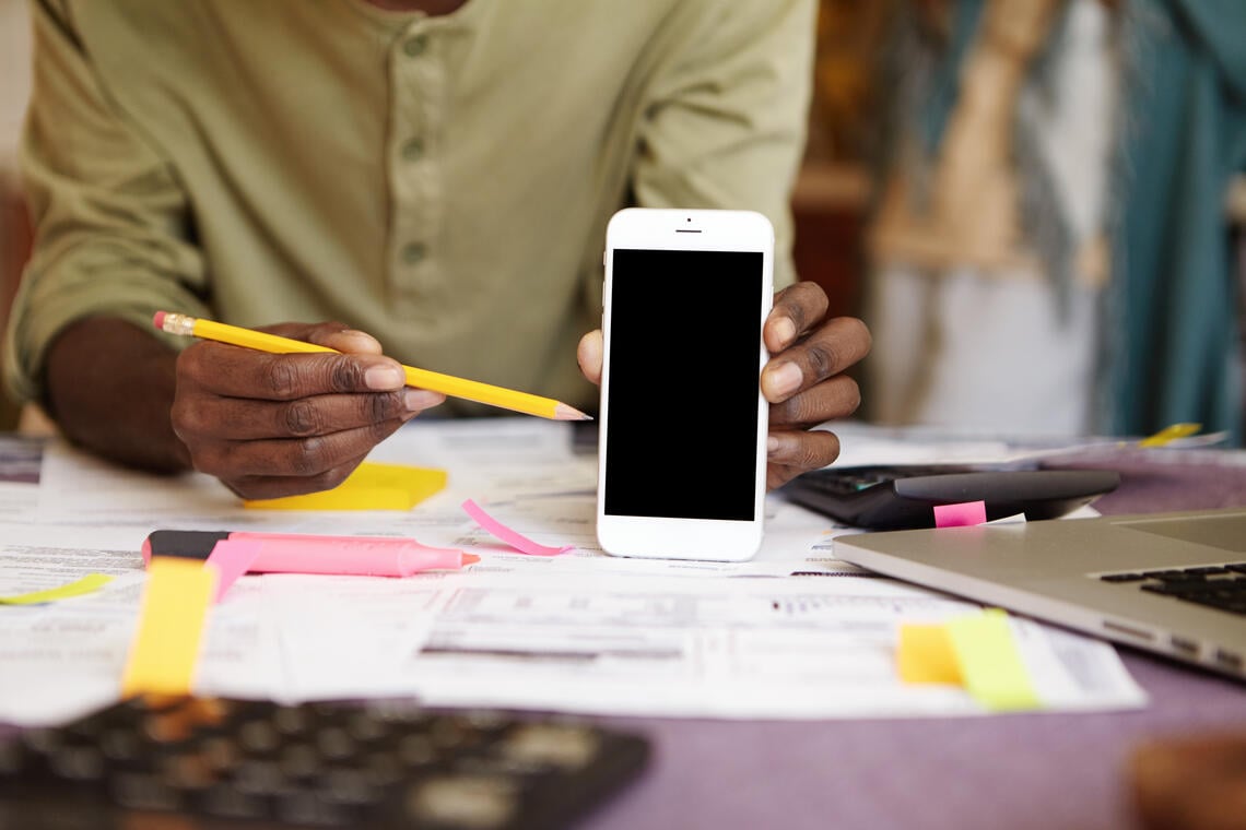 unrecognizable-african-man-holding-yellow-pencil-pointing-it-blank-screen-smart-phone-his-hand.jpg