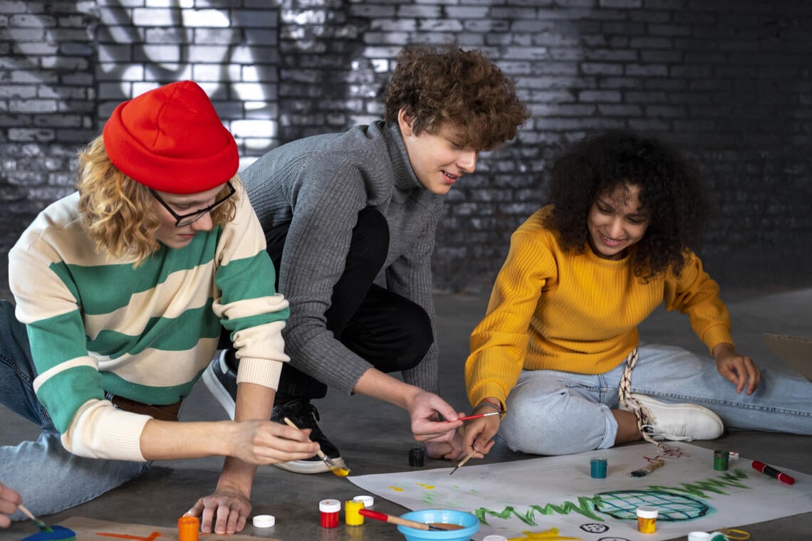 full-shot-young-people-making-banners.jpg