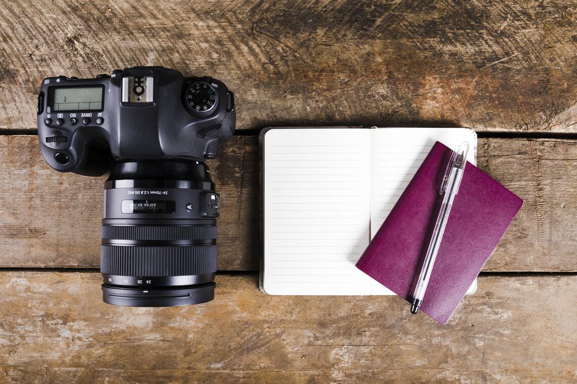 notepad-passport-pen-dslr-camera-wooden-background.jpg