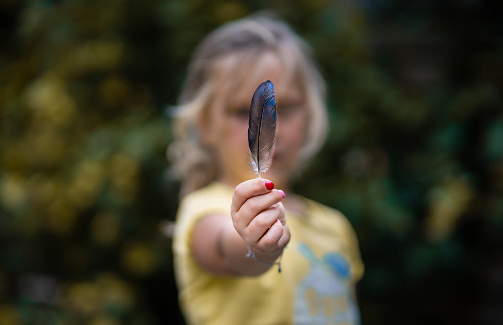 selective-focus-shot-girl-holding-colorful-feather-field.jpg