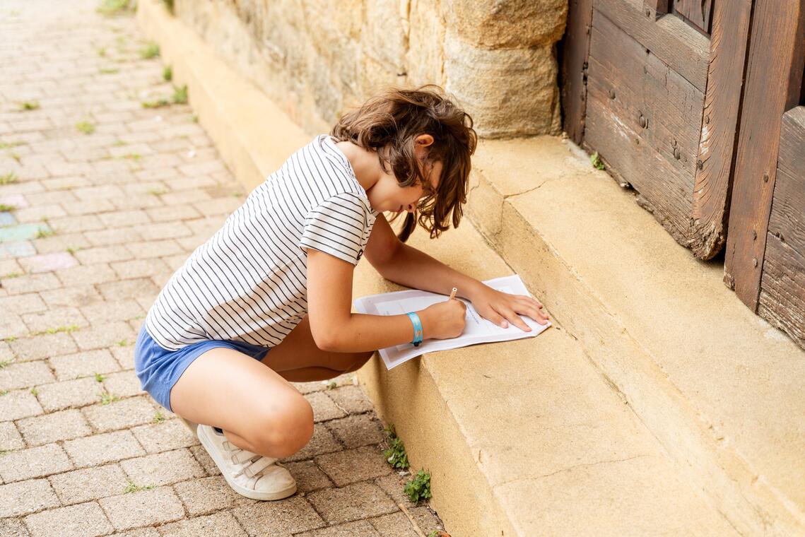 Visite Lud'Ambule enfant qui écrit sur le carnet