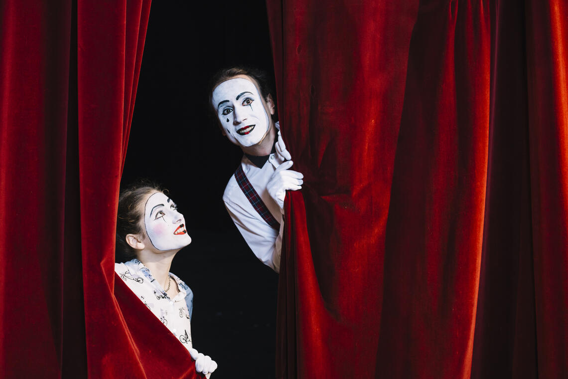 sourire-femme-mime-artiste-regardant-artiste-mime-male-furtivement-de-rideau