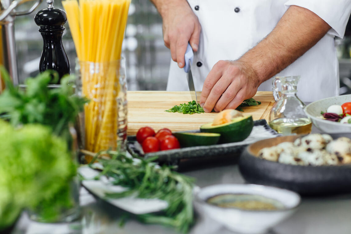 chef-coupant-le-legume-et-preparant-la-salade