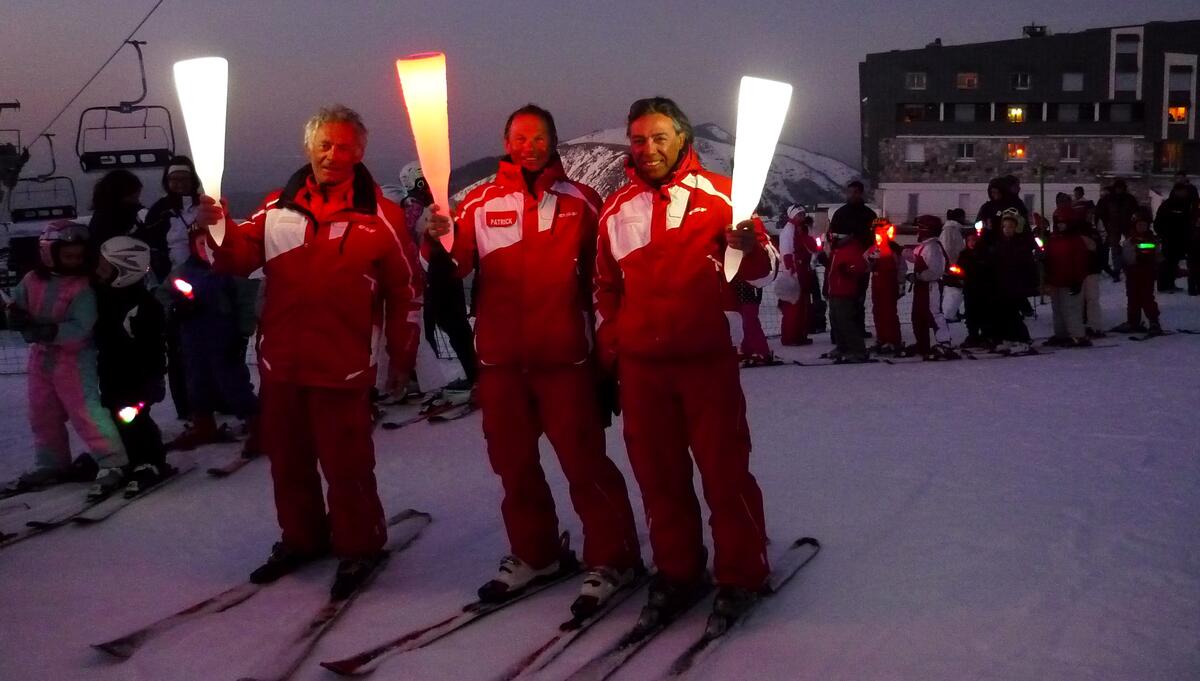 Moniteurs de ski encadrant la descente aux flambeaux