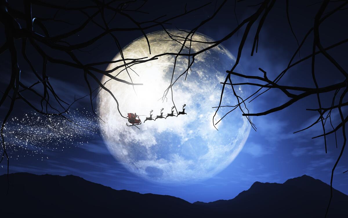 Santa Claus and his sleigh flying in a moonlit sky