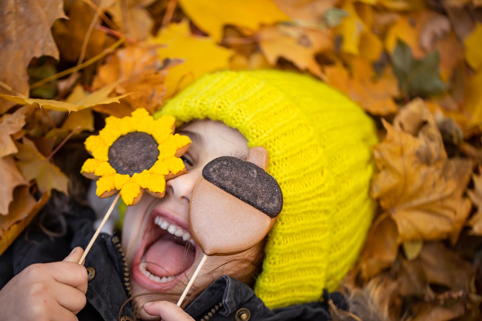 Bright autumn gingerbread in the hands of a child.