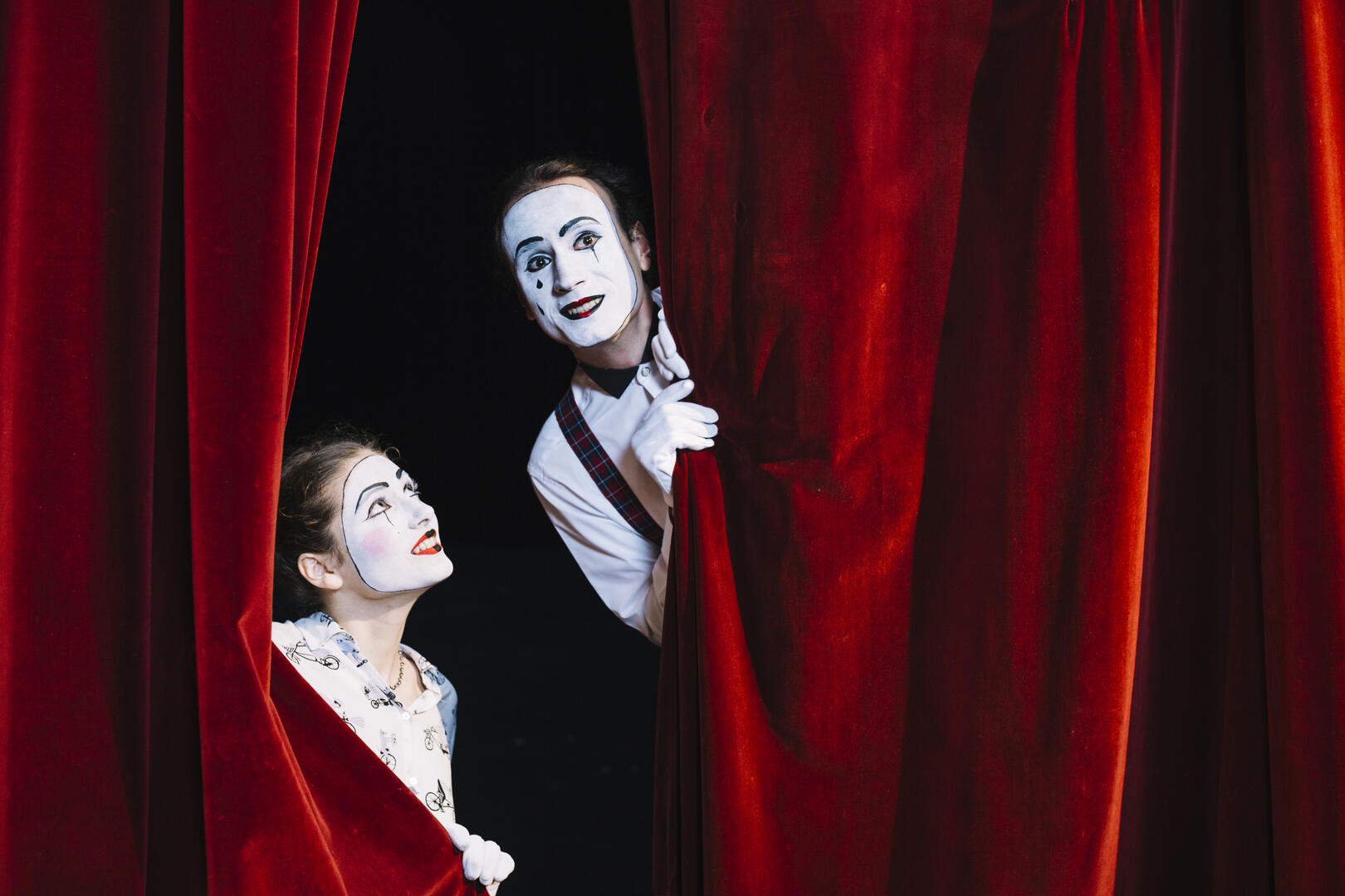 sourire-femme-mime-artiste-regardant-artiste-mime-male-furtivement-de-rideau