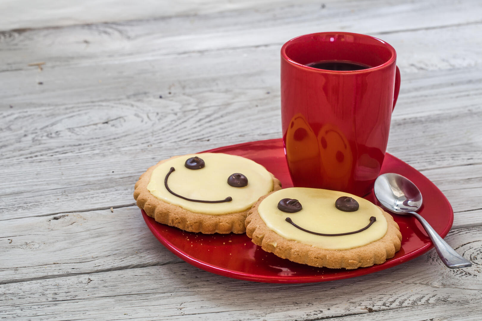 smile cookies on a red plate with Cup of coffee, wooden background, food