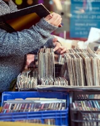Customer browsing vybyl discs at a vintage flea market.