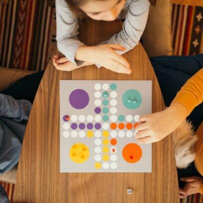 Above shot of family sitting at the table and playing board game