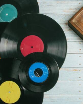 Old record player next to several vinyl records