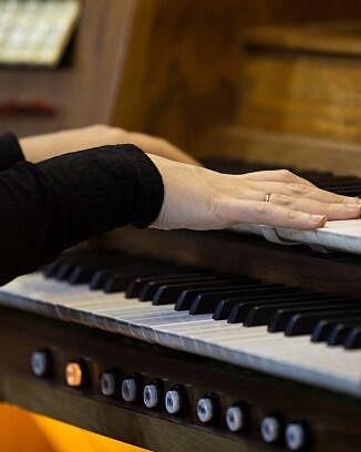 Hands of a woman playing the organ closeup