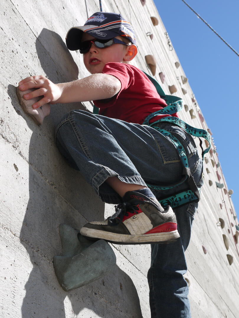 Enfant grimpant sur un mur d'escalade artificiel
