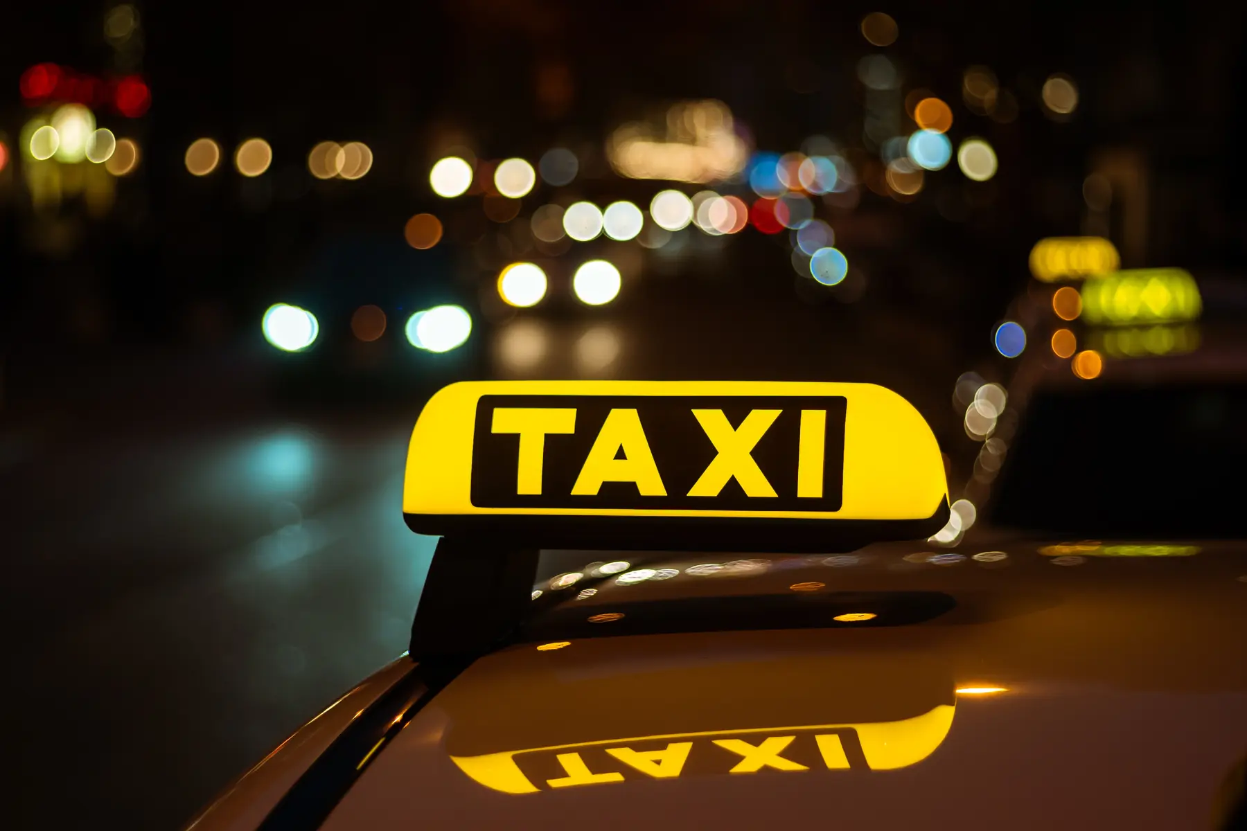 panneau-jaune-et-noir-de-taxi-place-au-dessus-d-une-voiture-pendant-la-nuit (2)