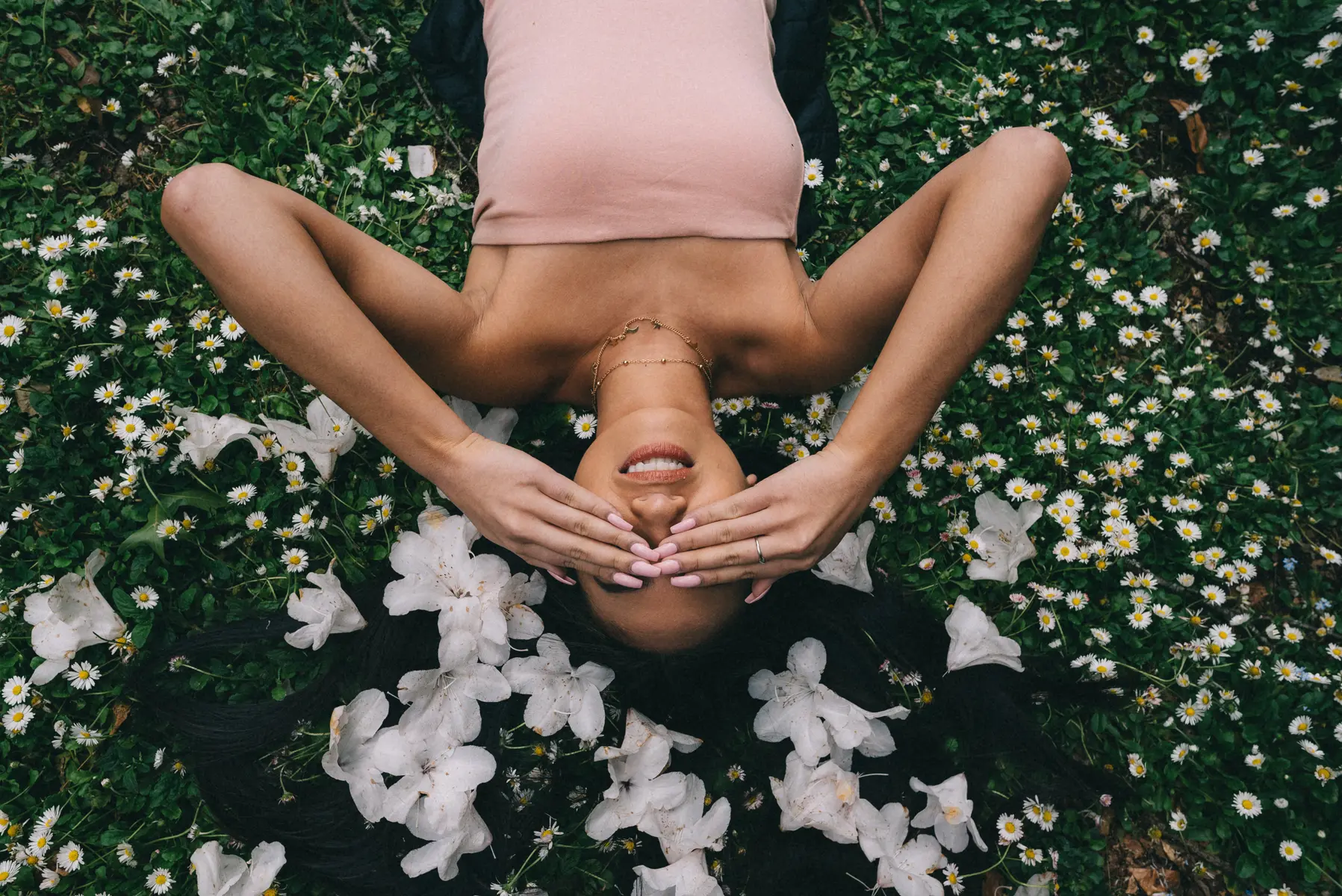 beautiful-model-laying-field-with-white-flowers