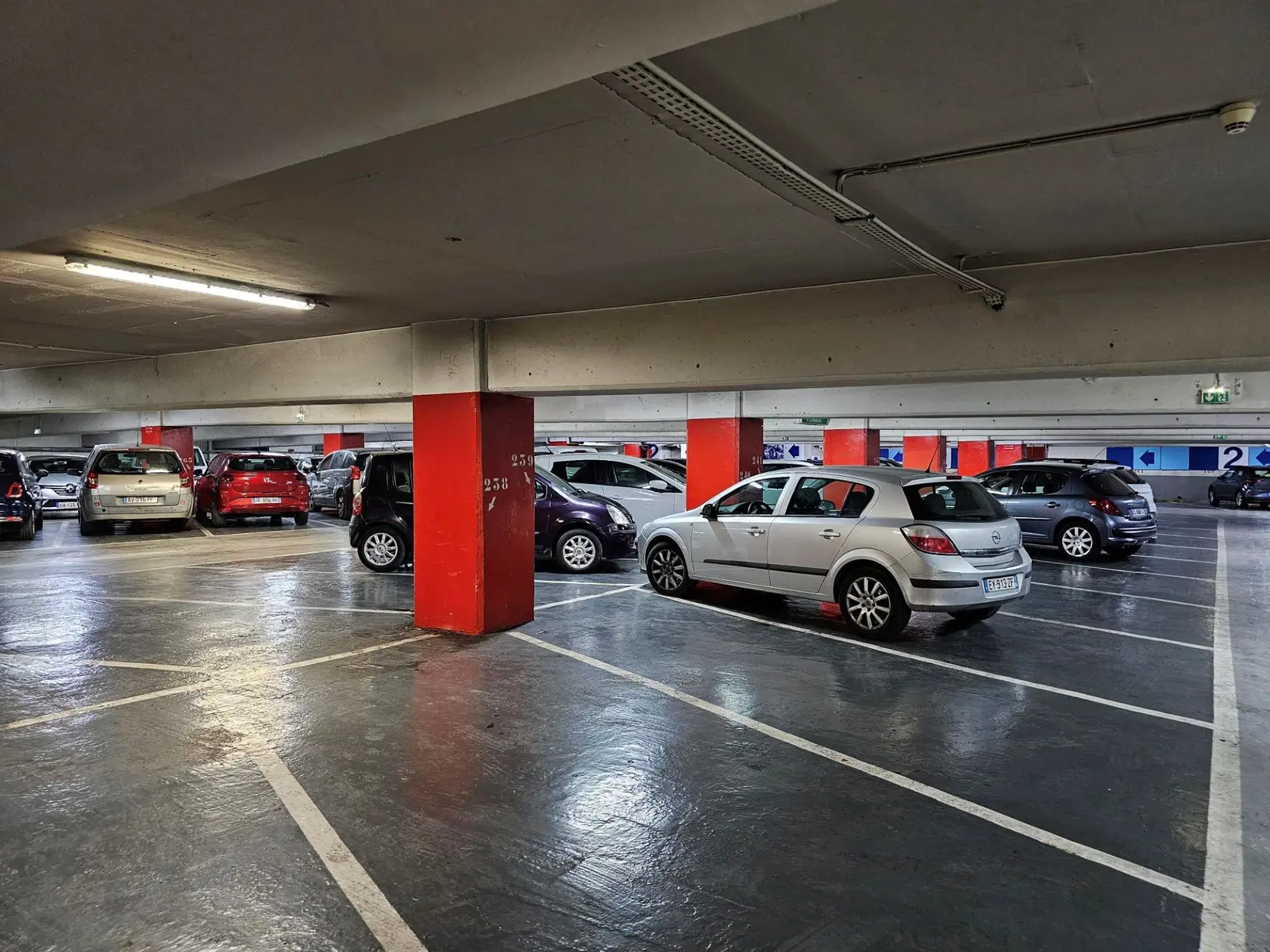 vue intérieur d'un étage du parking avec des véhicules stationnés