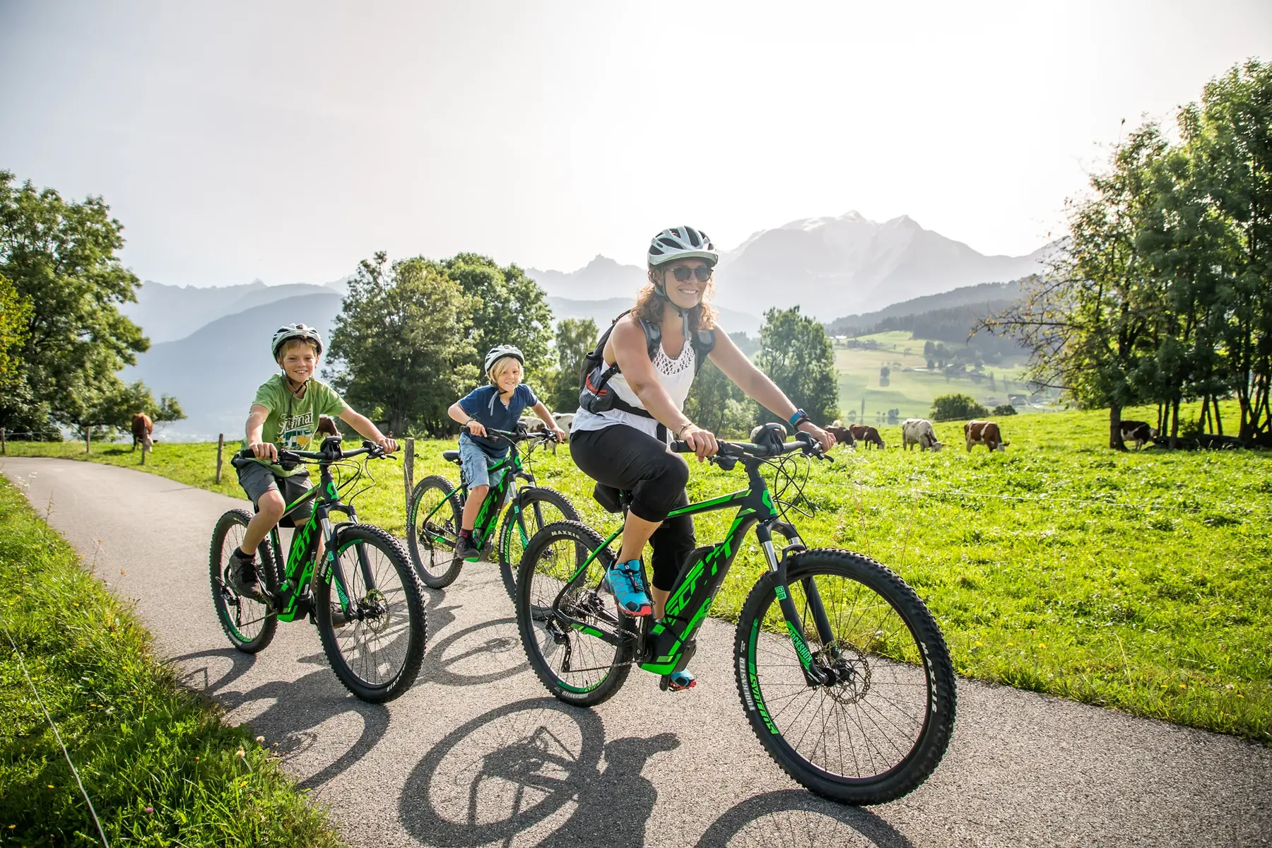 famille en VTT avec vaches et Mont-Blanc en arrière plan