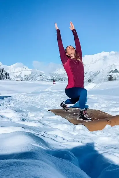 Personne pratiquant le yoga sur un tapis dans la neige