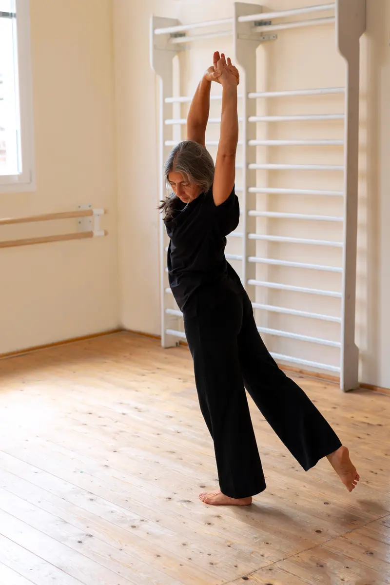 Une femme senior effectuant des mouvements de stretching dans un studio de danse