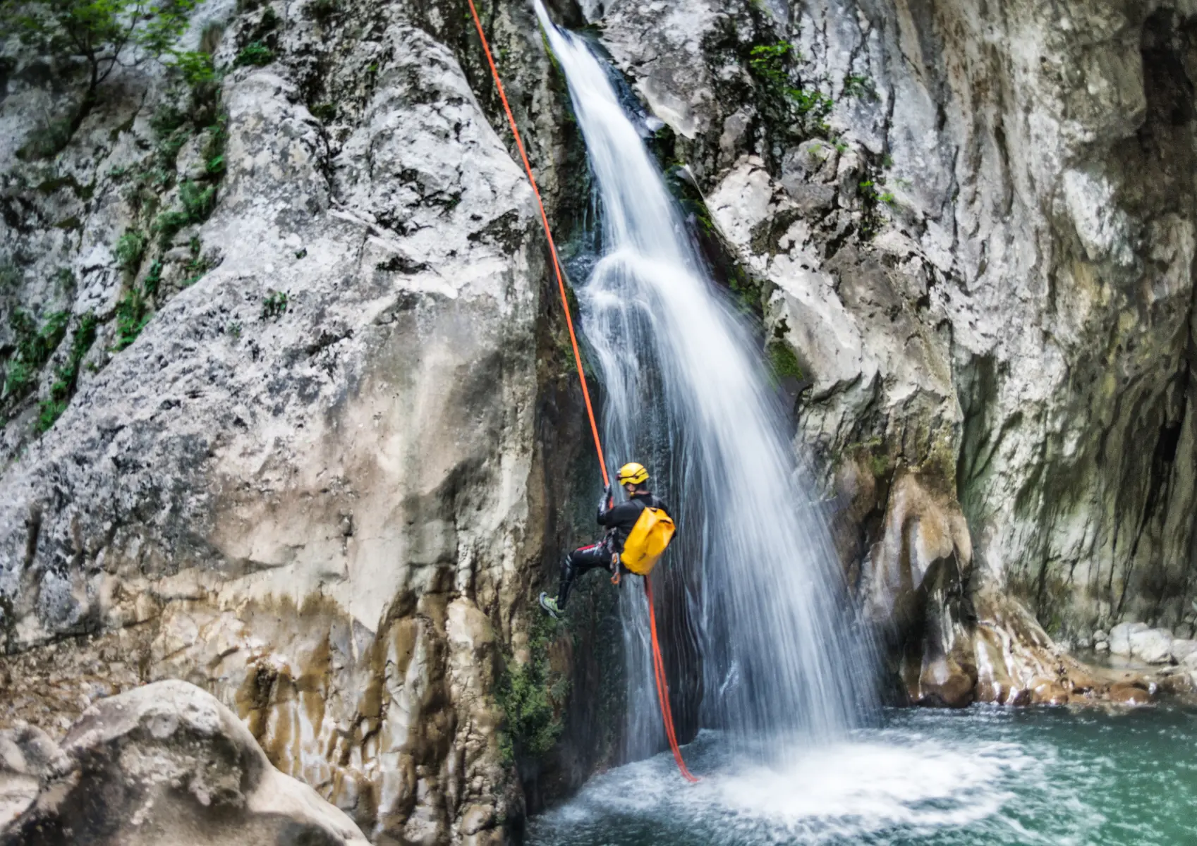 Persoon die een waterval afdaalt