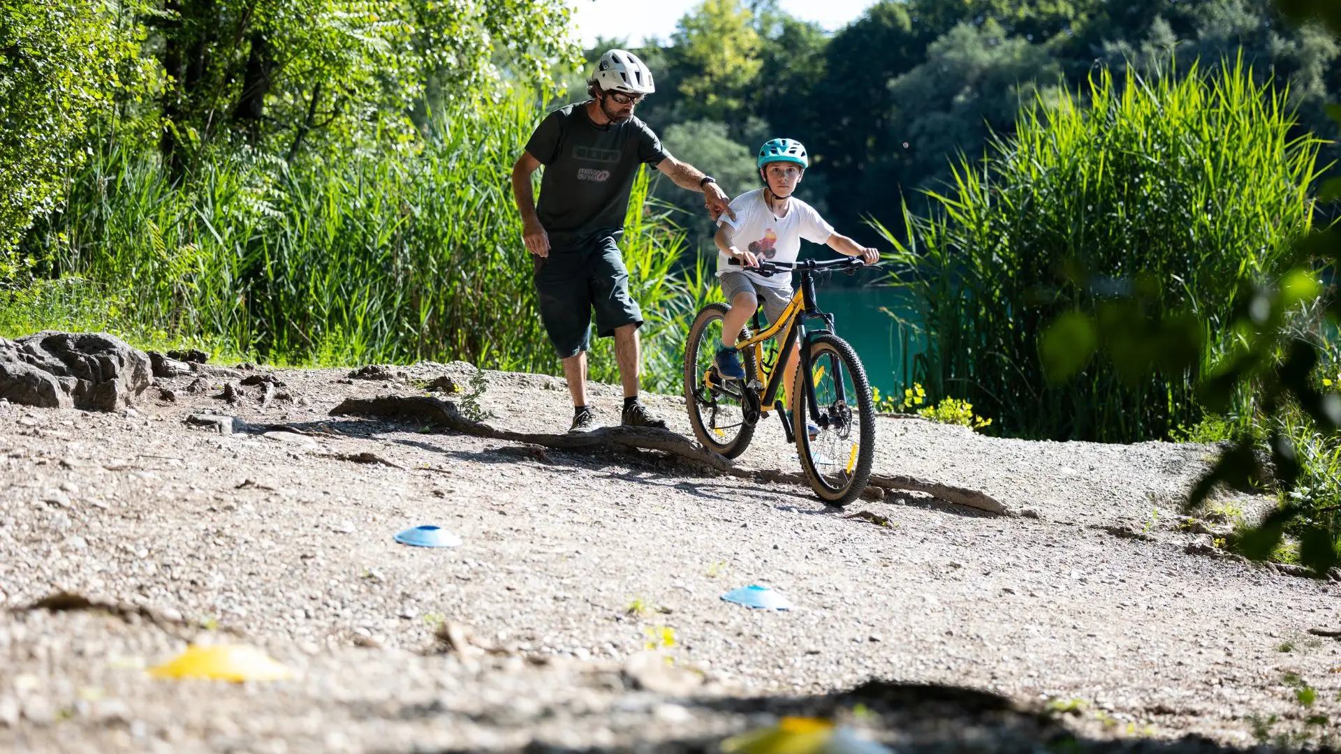 enfant sur un VTT avec le prof à côté