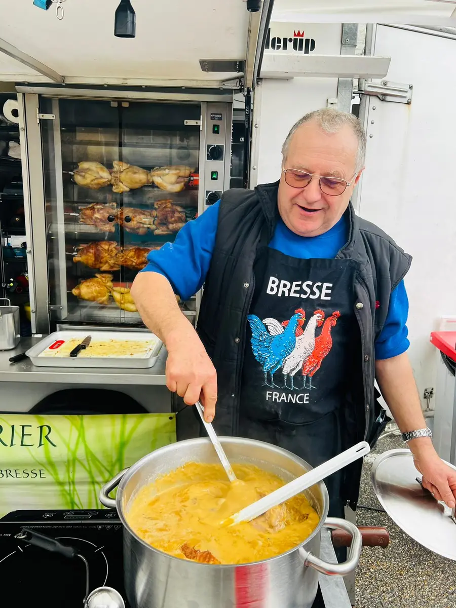 Joël Billet préparant le poulet de Bresse à la crème au marché Cerdon Cuivrerie en mars
