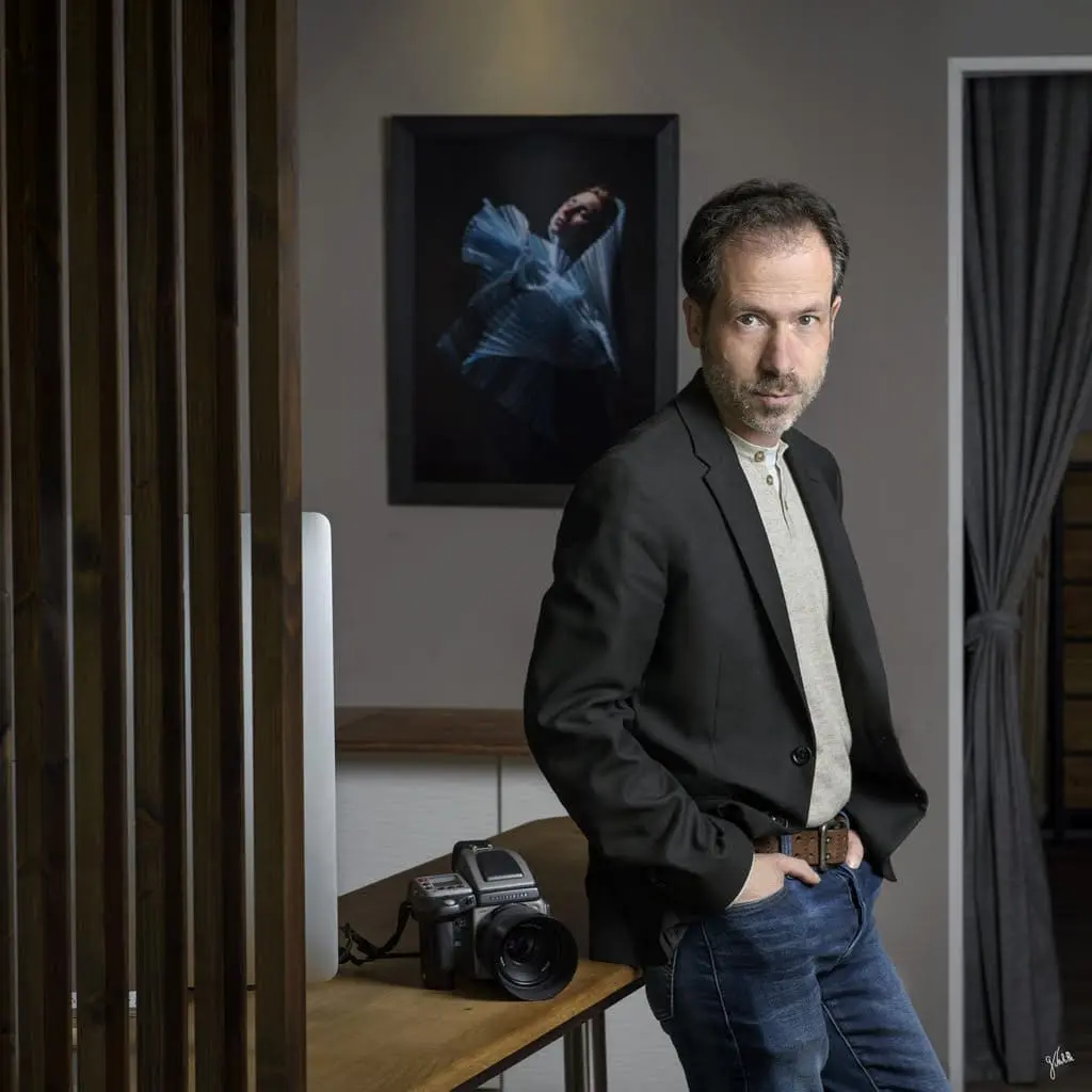 autoportrait du photographe adossé contre une table