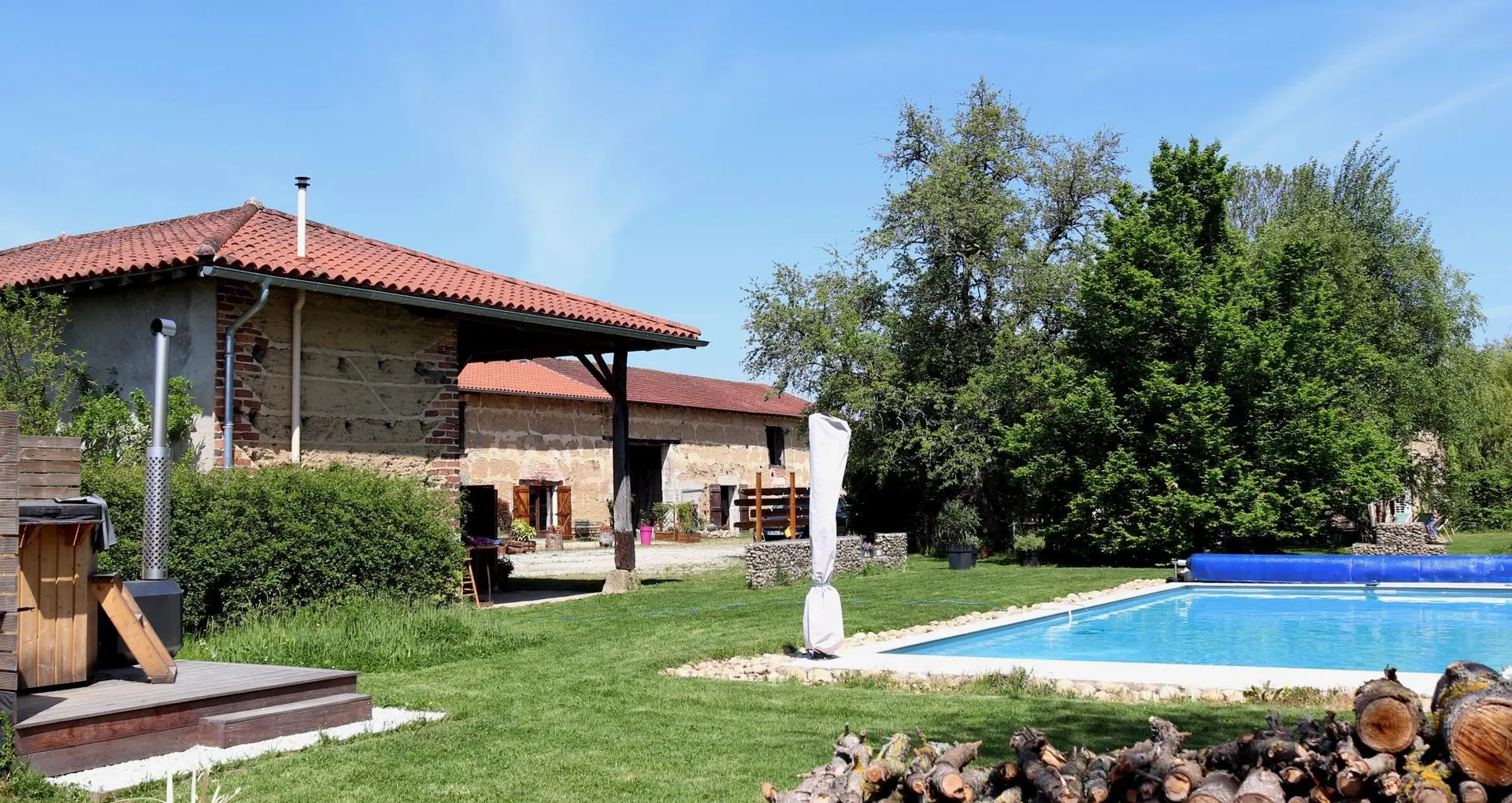 La piscine et l'espace jeux sous le hangar, avec vue sur le gîte L'Etable au fond