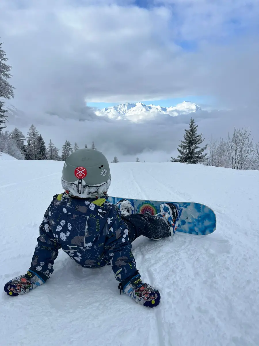 Un enfant dans la neige en snowboard