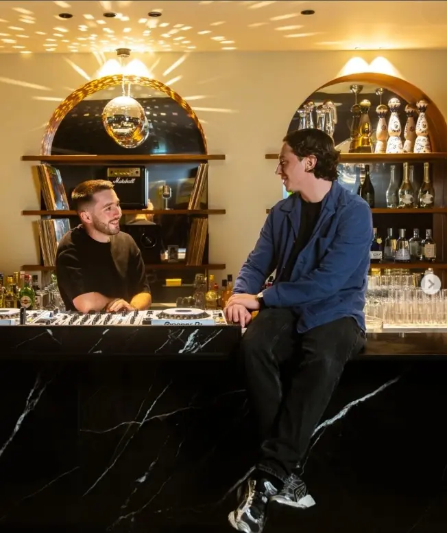 2 des 3 amis en train de discuter autour du comptoir