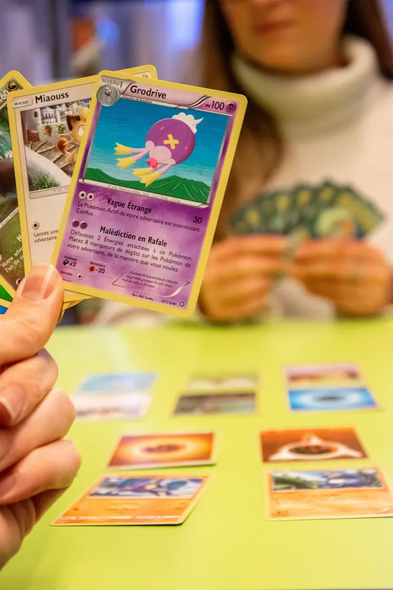 Personnes entrain de jouer aux cartes pokémon