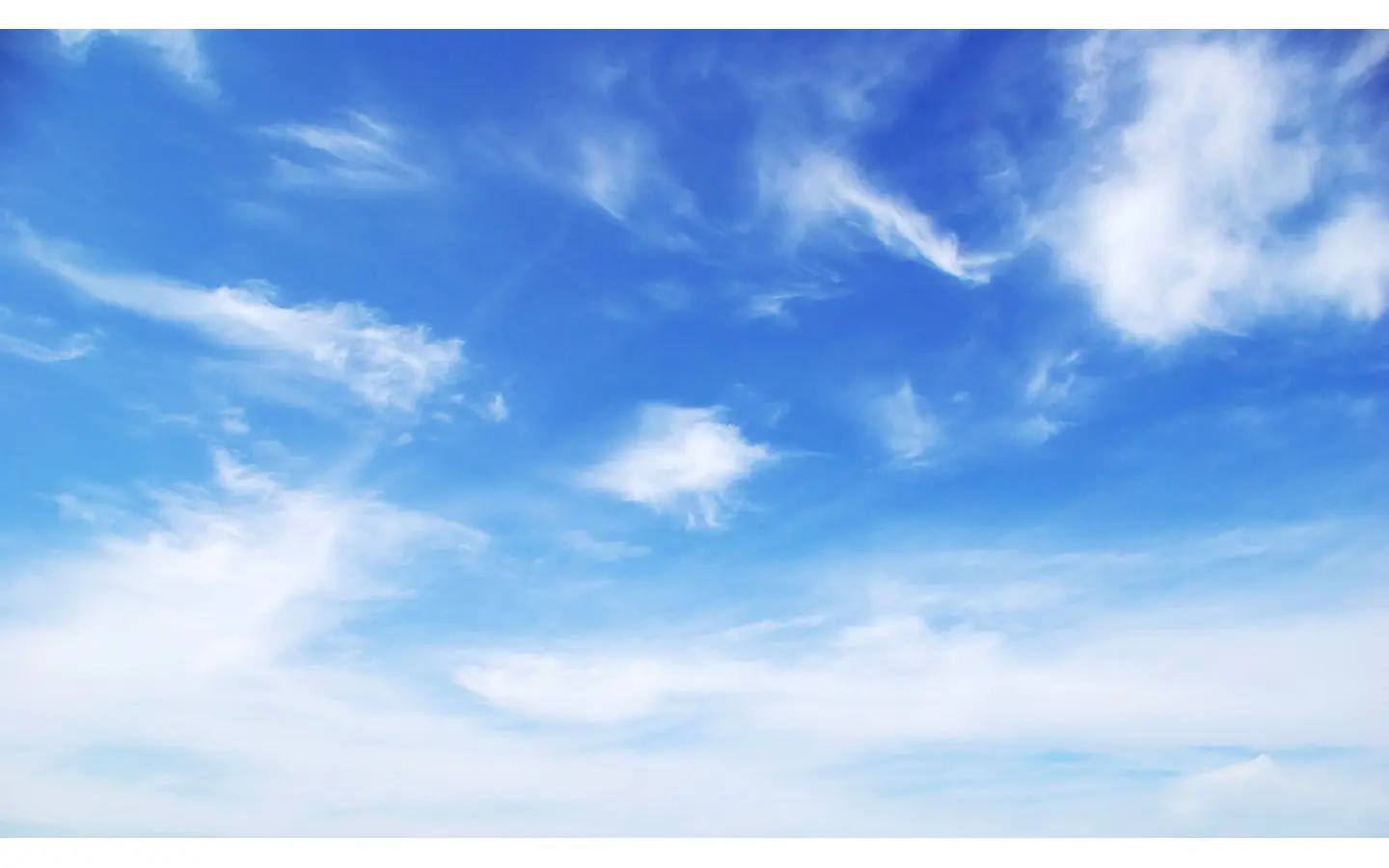 Blue sky background with tiny clouds