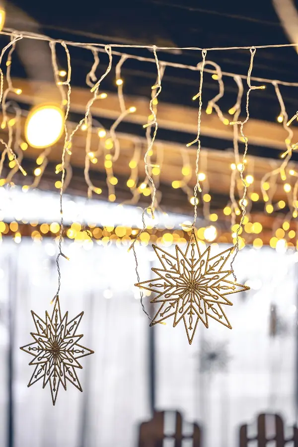 Decorative snowflakes and garlands on a blurred interior background.