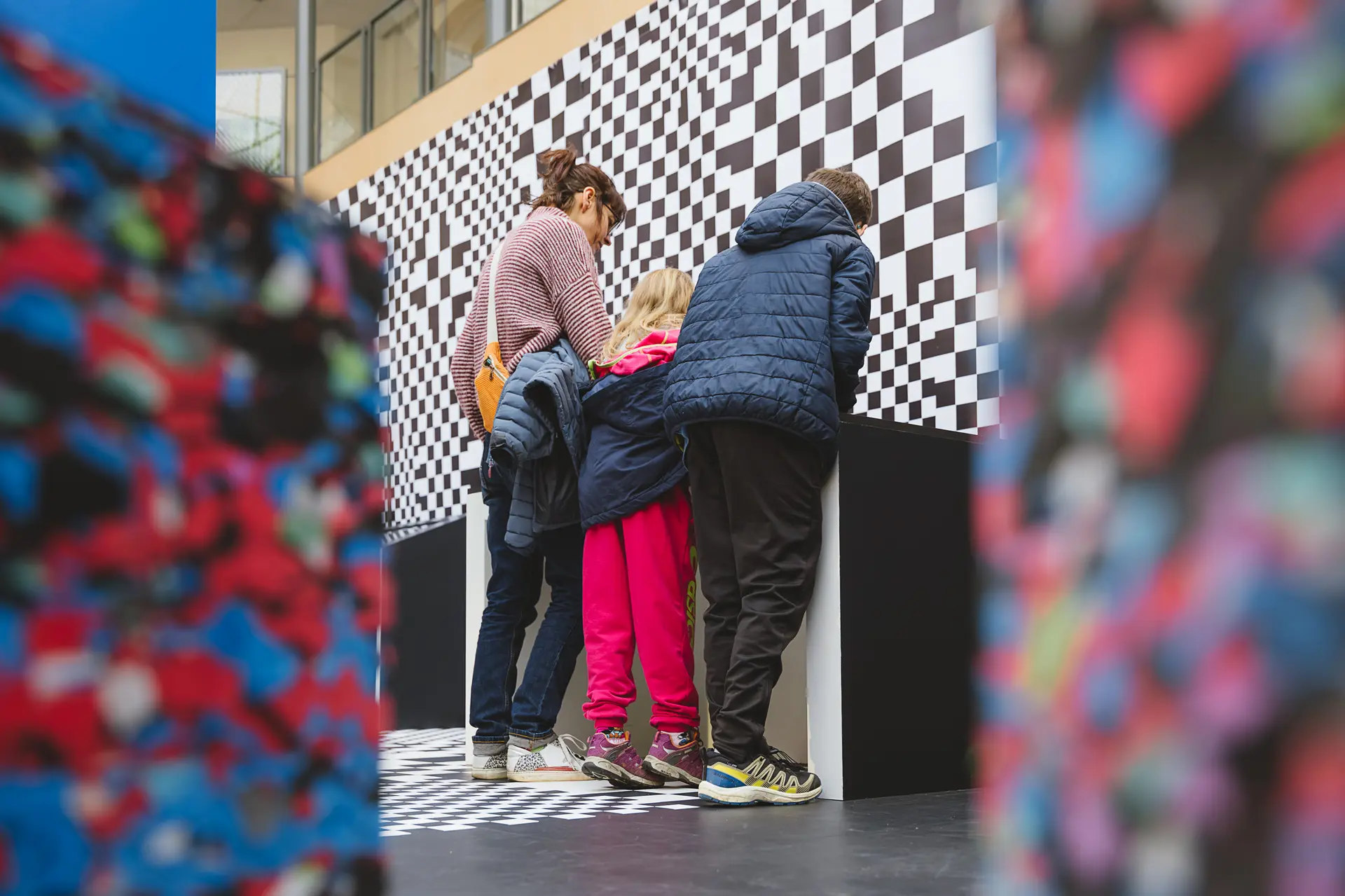 Famille sur les écrans de jeu dans l'exposition Destination IA