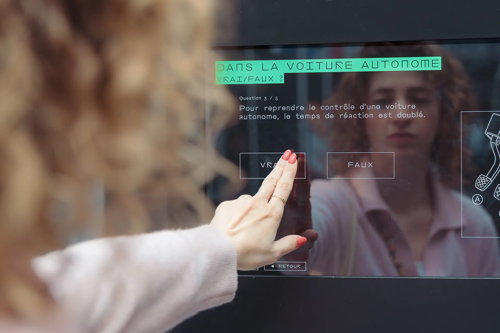 Visiteur sur la voiture autonome dans l'exposition Destination IA