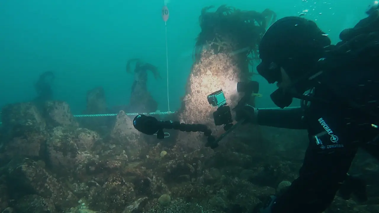 Le chercheur Philippe Bodénès près d’un monolithe planté dans le mur de Toul ar Fot, au large de l’île de Sein (Finistère)
