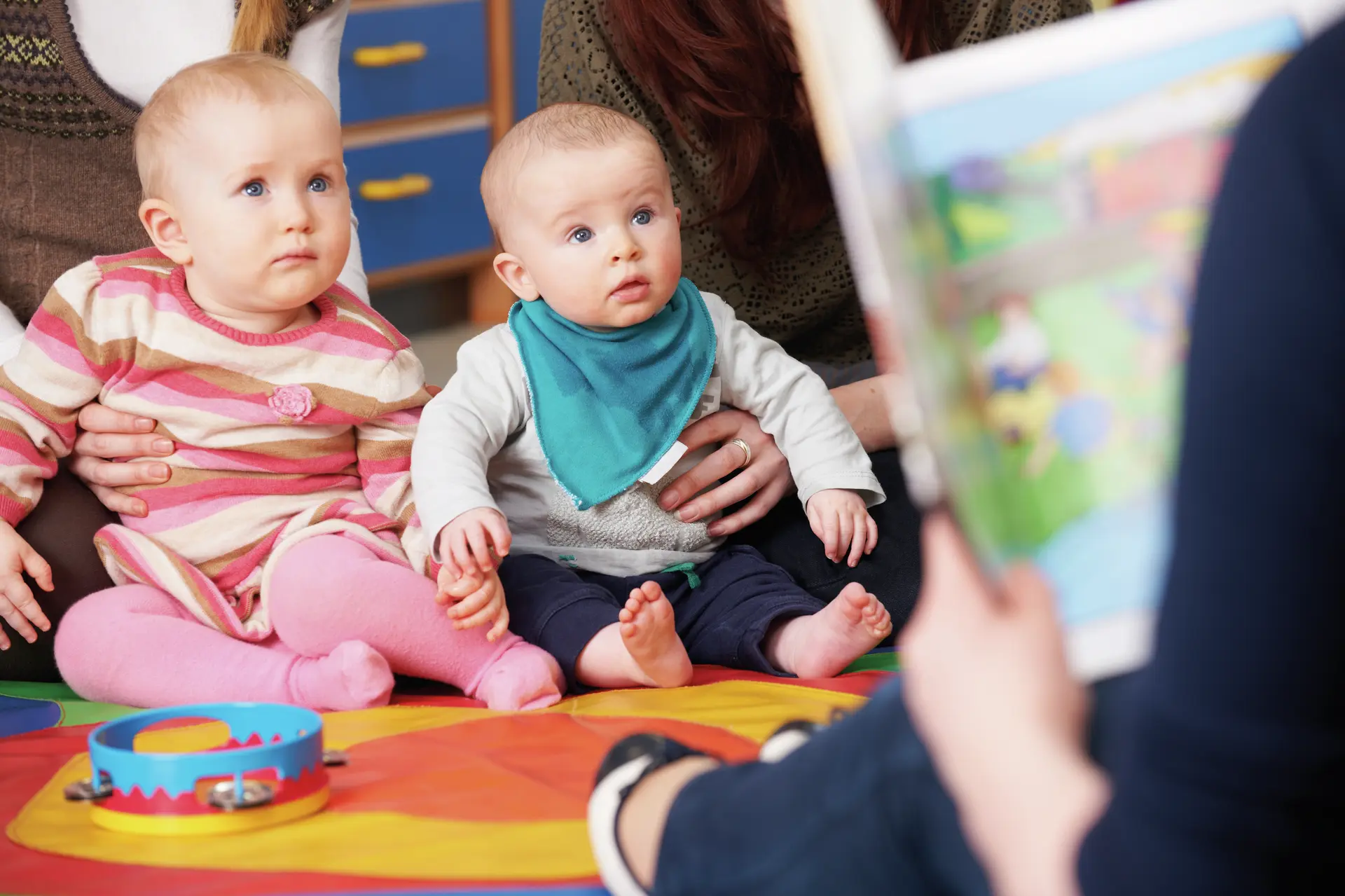 Mothers With Children At Baby Group Listening To Story
