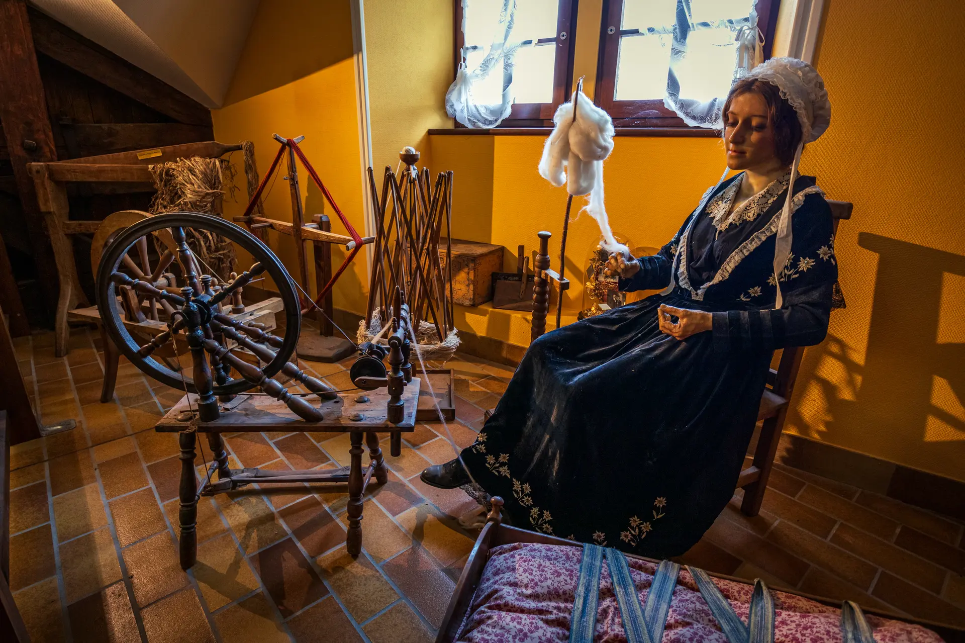 reconstitution d'une scène de la vie de l'époque - femme utilisant le rouet pour filer la laine