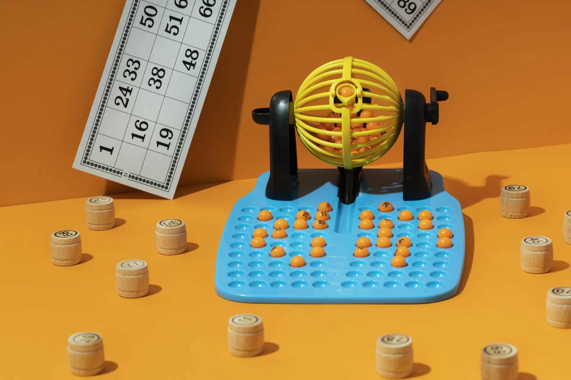 Des jetons et des cartons de loto sur un fond orange.