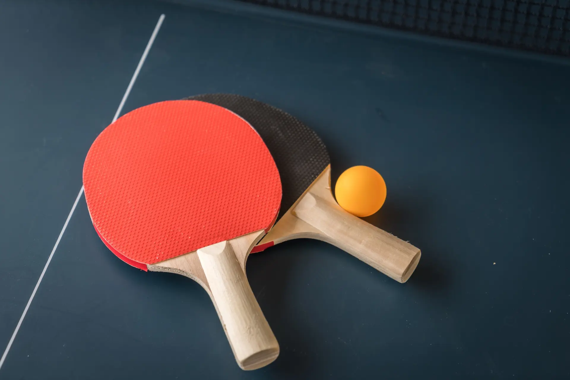 Deux raquettes de ping pong posées sur une table de ping pong.