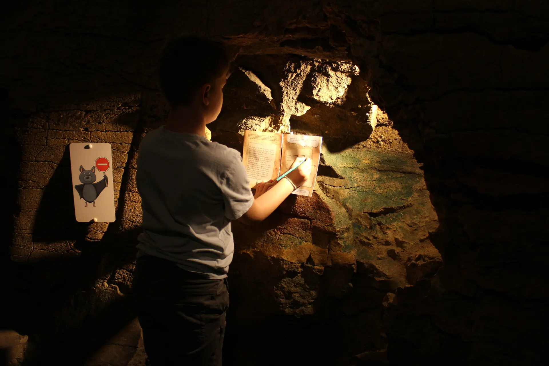 Enfant remplissant son livret de jeu