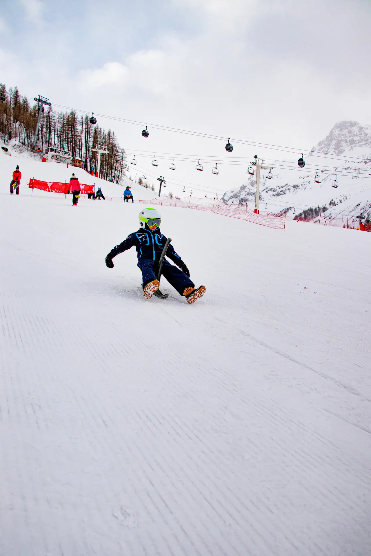 Enfant sur un Yooner à Val d'Isère en hiver sur la piste de la Savonnette