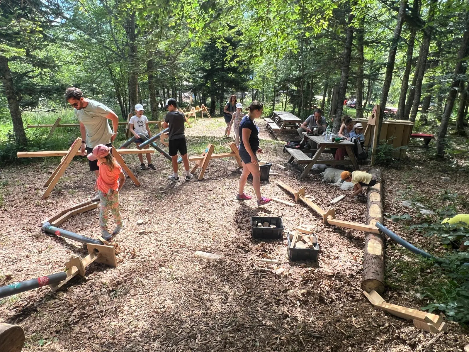 Famille testant le parcours éphémère Roule ma Boule qu'ils ont créé, dans la forêt