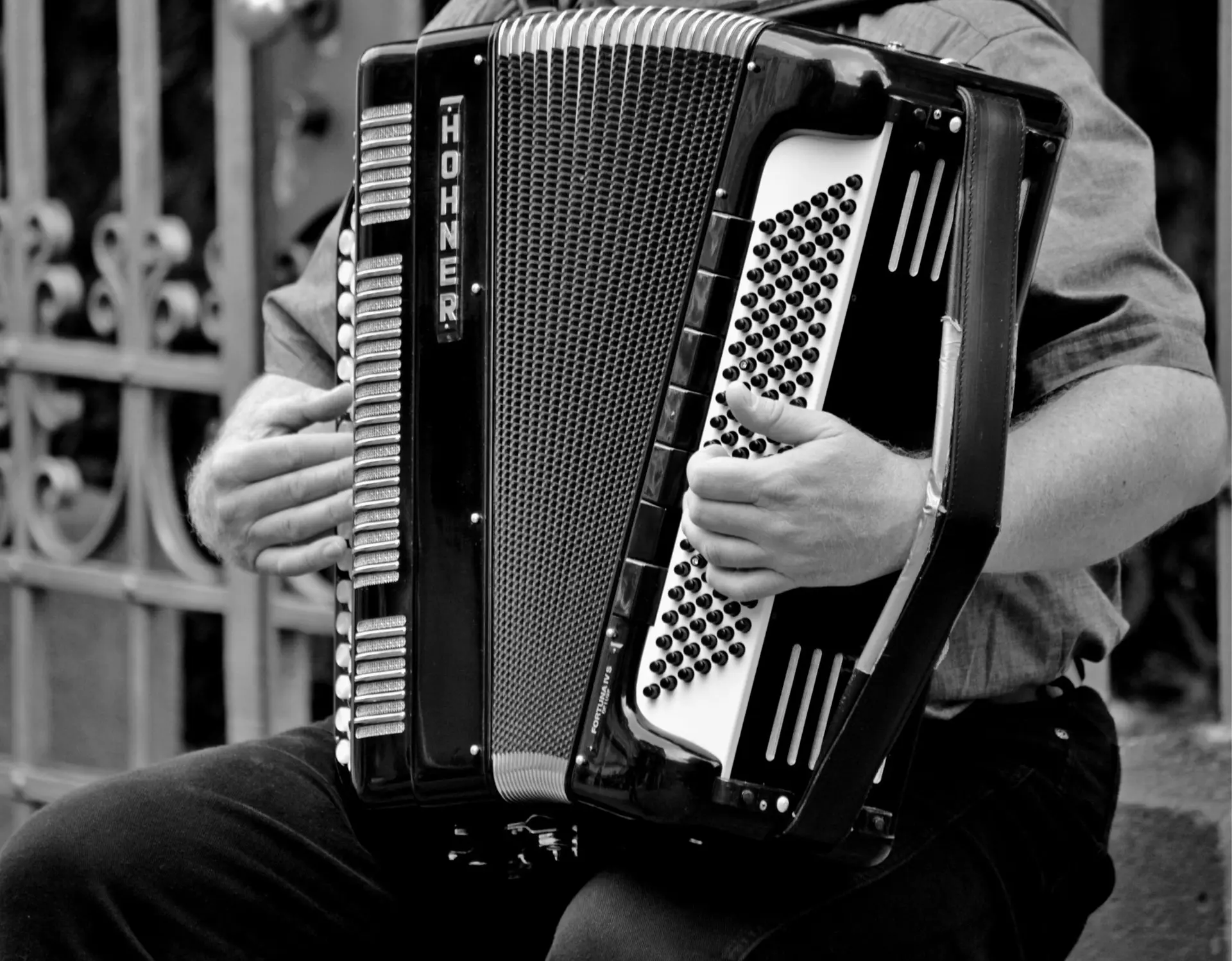 homme qui joue de l'accordéon en noir et blanc