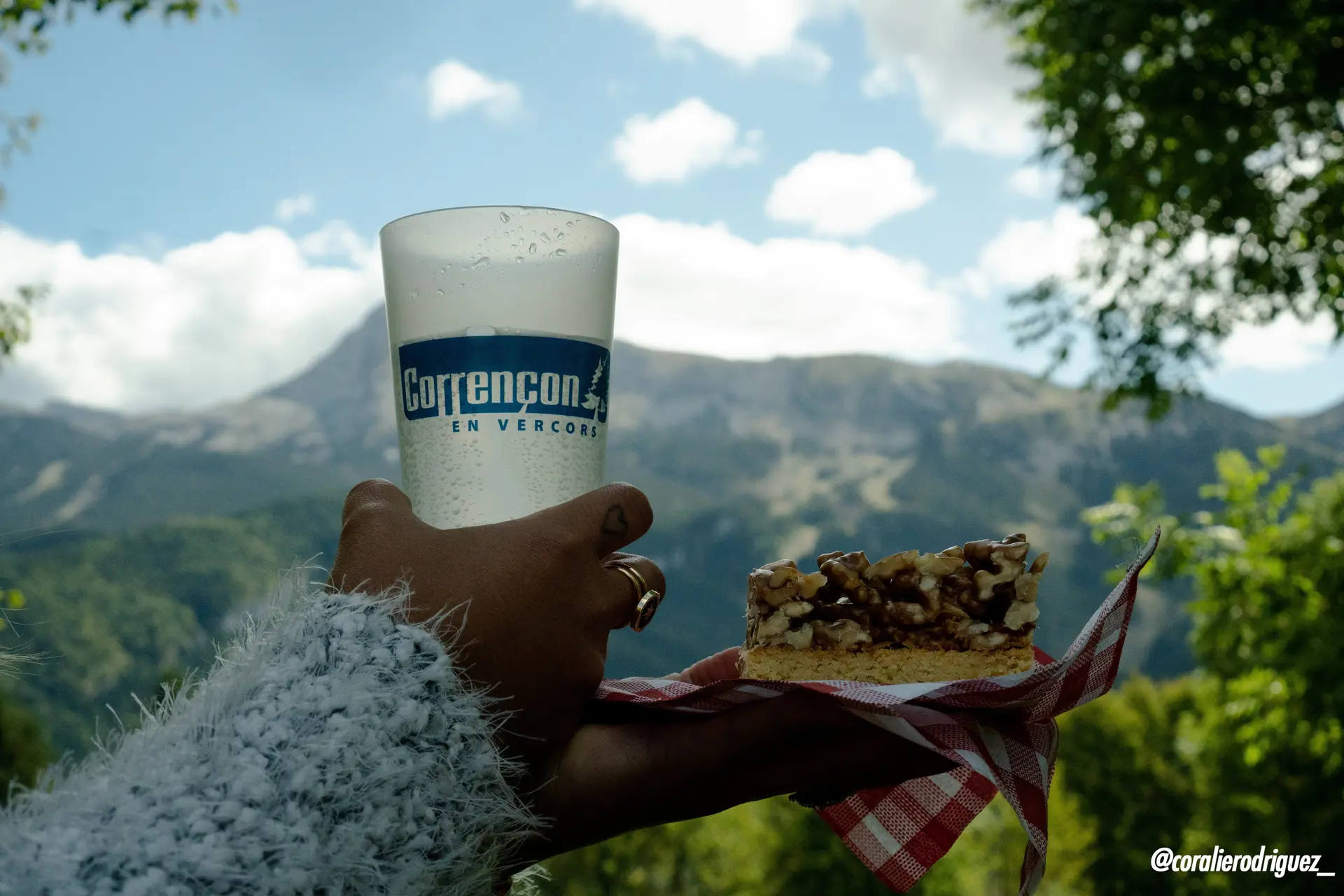 Photo d'un écocup Corrençon en Vercors et une tarte aux noix au premier plan avec les montagnes du Vercors au second plan