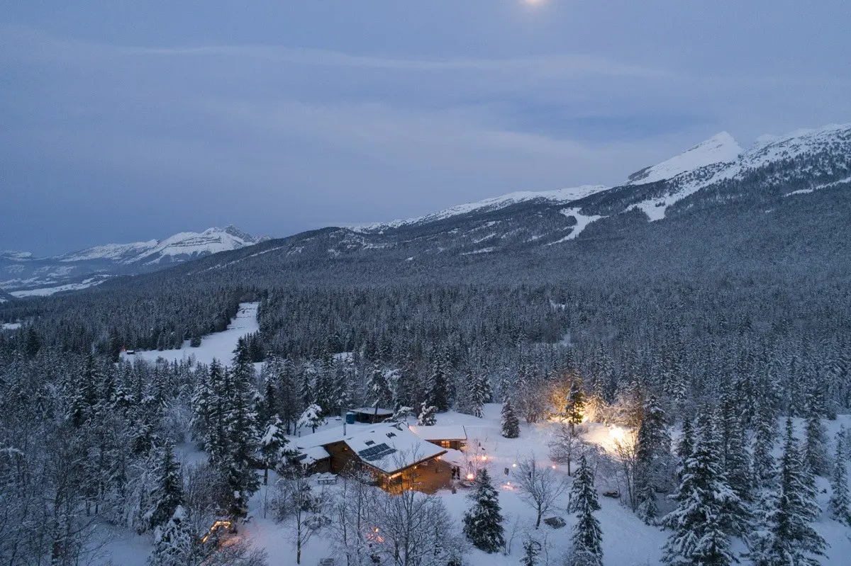 Chalet du Clariant, en bois, sous la neige, au milieu d'une forêt de sapins enneigés