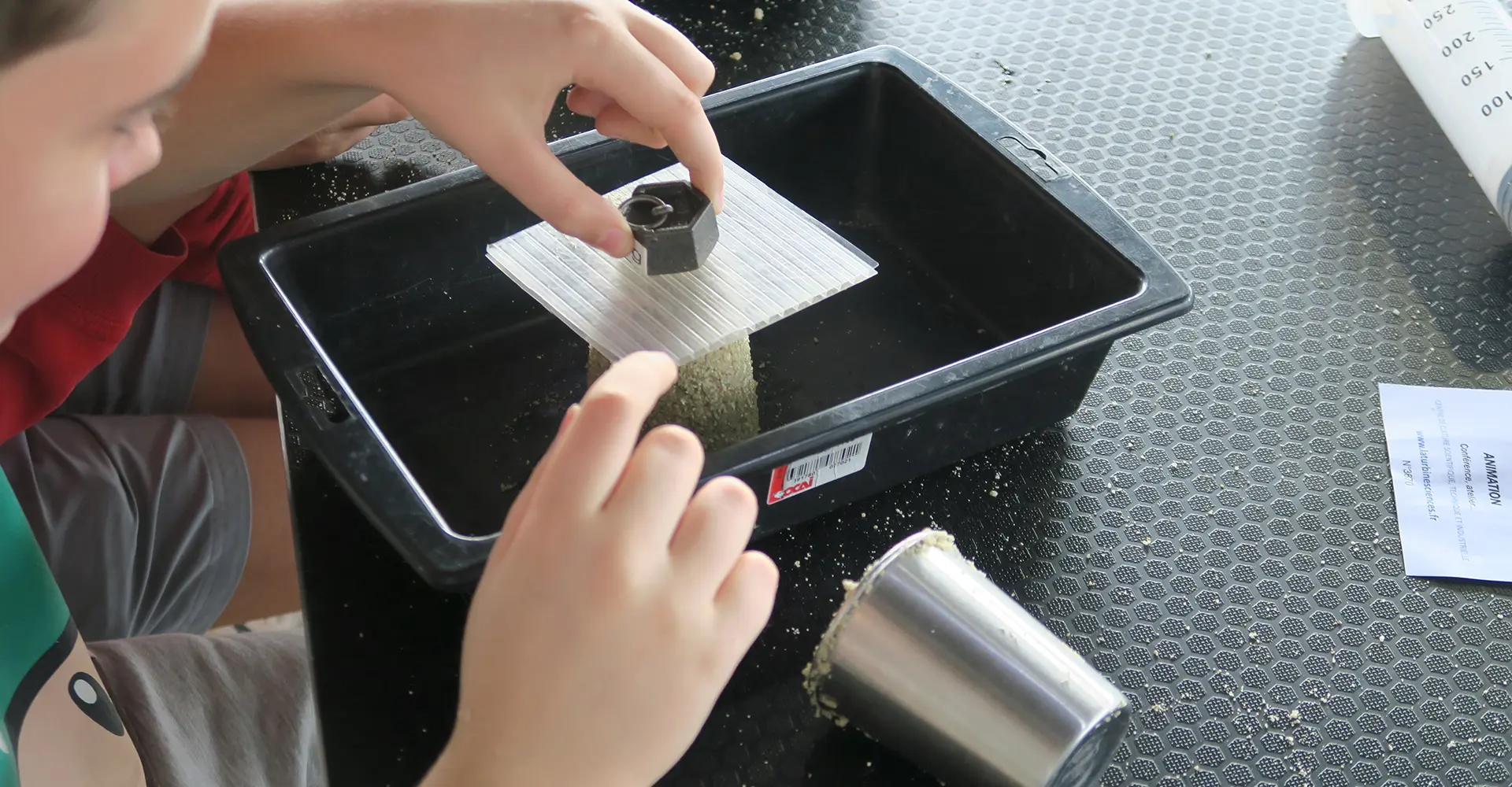 Un enfant expérimente le poids sur du sable