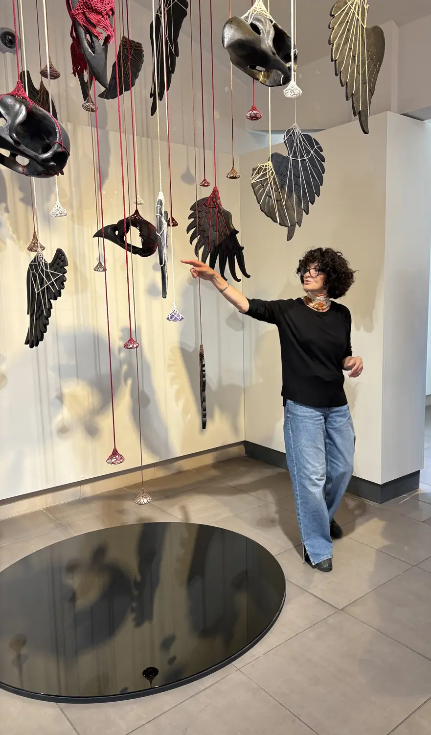 artiste avec ses oeuvres suspendues