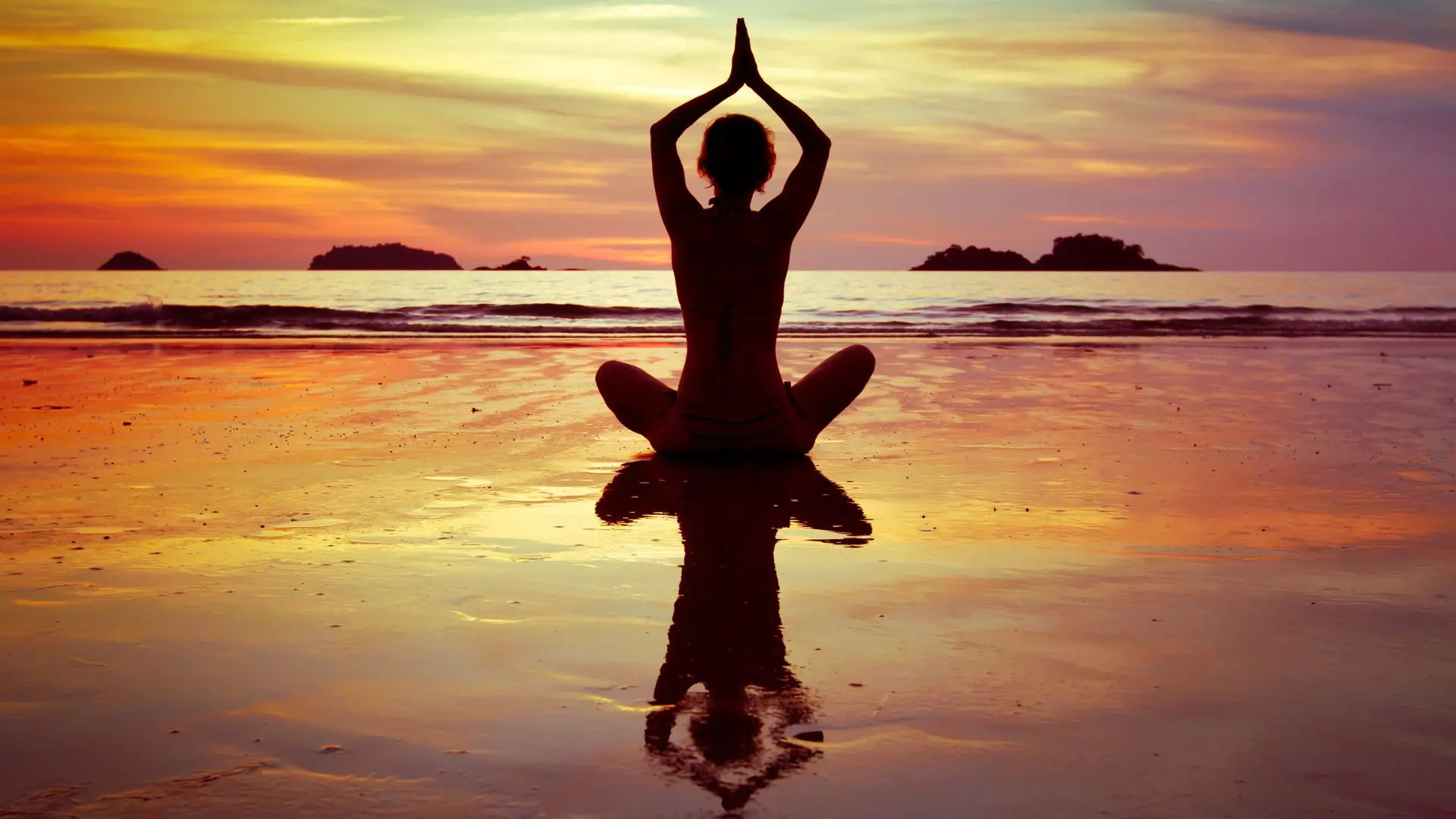 femme faisant du yoga sur une plage